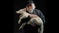writer-george-martin-holds-a-wolf-with-its-mouth-open-and-smiles66.jpg