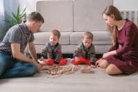 family-mom-dad-two-twin-brothers-play-together-building-out-wooden-blocks-floor-131563567[1].jpg