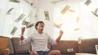 happy-man-with-cash-dollars-flying-in-home-office-rich-from[...].jpg